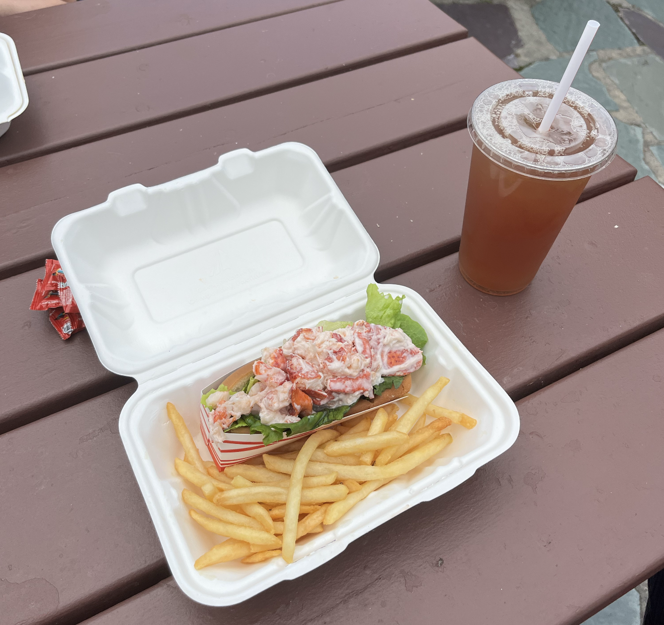 Cedar Hill Dairy Joy Lobster Roll - on a picnic table with fries and an iced tea