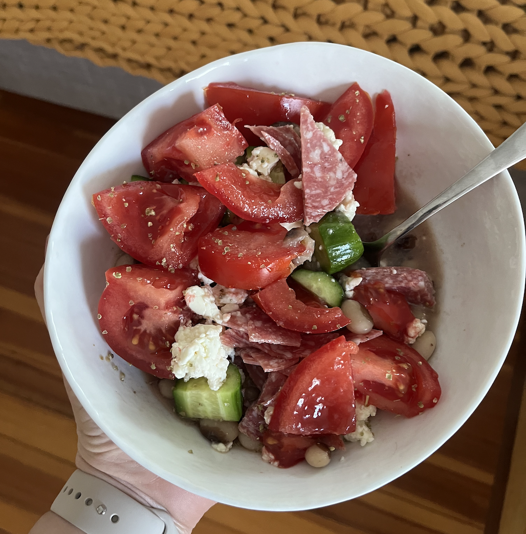 Bowl of tomatoes and cucumbers and feta and salami and beans