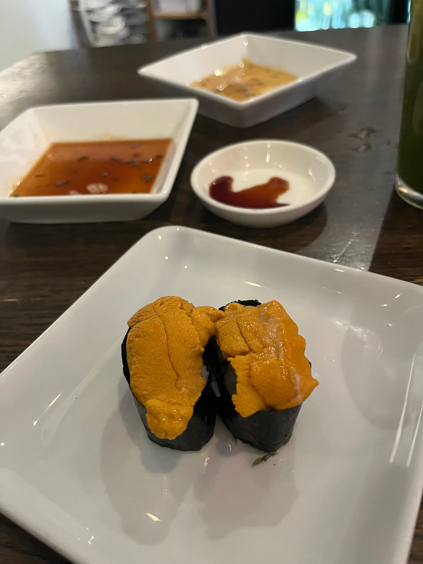 two pieces of orange uni sea urchin sushi on a plate